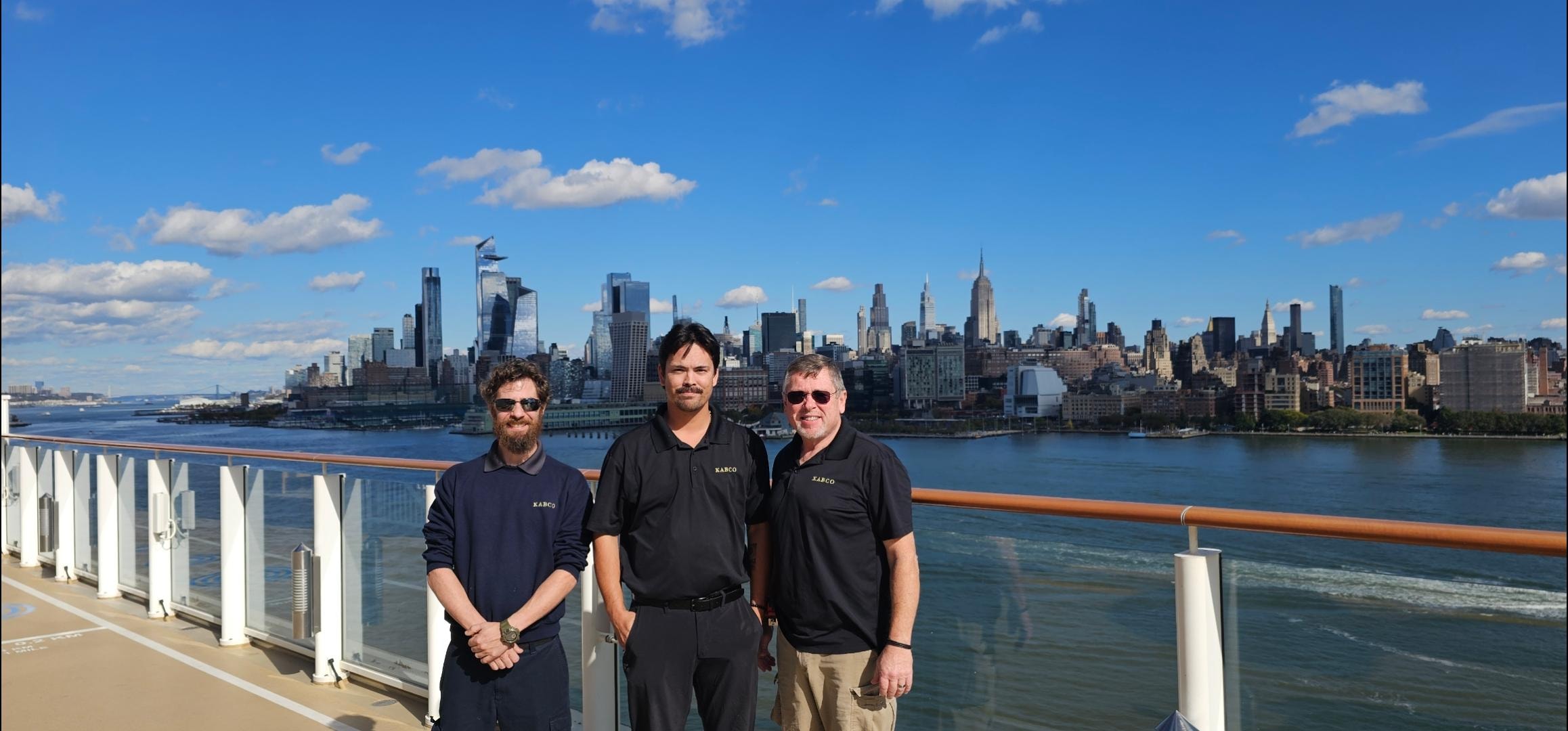 Kabco team on cruise ship deck with Manhattan skyline