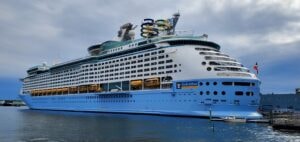 Large blue cruise ship docked in harbor